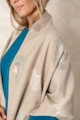 Pashmina reversible de textura suave y caída fluida, con diseño estampado de hojas de ginkgo biloba. Presenta un lado con fondo oscuro y otro con fondo claro, finalizando en ambos extremos con flecos cortos deshilachados.