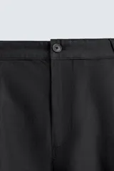 Pantalón de corte relaxed fit confeccionado en mezcla de algodón y modal. Presenta cintura con pliegues frontales, bolsillos laterales y bolsillos traseros con solapa. Cierre frontal con cremallera y botón.