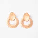 Aros colgantes de diseño geométrico con acabado texturizado y efecto martillado en tono dorado.