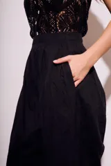 Pantalón negro de corte amplio, con cintura elástica y textura arrugada.