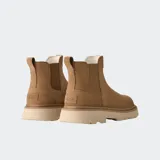 Bota tipo Chelsea de gamuza color marrón, con paneles laterales elásticos, lengüeta trasera y suela de plataforma dentada en tono crema.