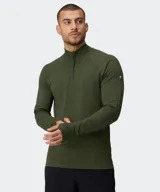 Remera deportiva de manga larga Fabletics modelo The Training Day, color verde militar, con cuello alto y cierre frontal parcial. Cuenta con tecnología antiolor y ojal para el pulgar en los puños.
