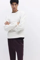 Jogger color bordó en tejido suave de mezcla de algodón, con pliegue cosido en la parte delantera. Presenta cintura elástica con cordón ajustable, bolsillos laterales y un bolsillo insertado en la parte trasera.