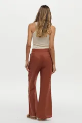 Pantalón largo color ladrillo de corte recto y holgado en las piernas, con pretina ancha y cierre frontal oculto.