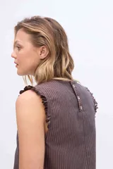 Musculosa gris a rayas verticales, con cuello redondo y detalles de volados fruncidos en la línea central delantera y en las sisas.