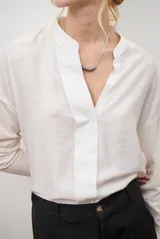 Blusa de color azul oscuro, con cuello mao y escote en V. Presenta mangas largas con puños abotonados y un corte recto y holgado.