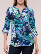 Blusa de gasa estampada de la marca Zac & Rachel, con diseño floral en tonos azul, celeste y verde sobre base blanca. Presenta escote en V con abertura y botones frontales, y mangas largas de largo regulable con presilla.