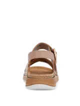 Sandalias de mujer color beige, con tiras cruzadas en la parte frontal, una de ellas con textura metalizada, y tira ajustable al talón con hebilla. Posee suela de plataforma con detalle estilo yute.