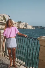 Camiseta gris con efecto lavado, cuello redondo con ribete y mangas cortas tipo capa.