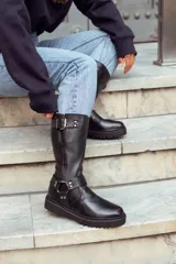 Botas de caña alta color negro, con hebillas y cierre lateral.