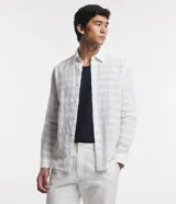 Camisa de hombre de corte regular, manga larga y cuello inglés, color blanco, confeccionada en una mezcla de algodón y lino con textura de cuadrícula sutil.