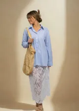 Camisa celeste a rayas verticales blancas, de corte oversize y manga larga.