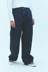 Jean de tiro bajo y corte oversize, confeccionado en denim azul con grabado láser de monograma en patrón de rombos. Presenta avíos metálicos y diseño de pierna ancha.