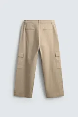 Pantalón cargo de corte relajado confeccionado en tejido de algodón con elasticidad. Presenta bolsillos laterales tipo cargo con solapa en las perneras, bolsillos frontales y bolsillos traseros de doble vivo. Cierre frontal con cremallera y botón.