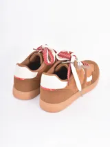 Championes de estilo urbano en color bordó, confeccionados en gamuza con detalles en cuero blanco. Presentan cordones gruesos con estampado de lunares y suela de goma color caramelo.