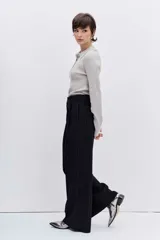 Jersey de punto color beige con cuello polo y cierre frontal de botones. Presenta mangas largas y un ajuste entallado al cuerpo.