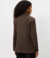 Blazer sastrero de corte alargado con estampado de cuadros pequeños en tonos marrones. Presenta cuello con solapa, cierre frontal con dos botones y mangas largas.