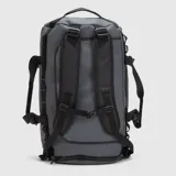 Bolso tipo duffel de diseño versátil, color gris con detalles en negro. Cuenta con un compartimento principal amplio, bolsillos exteriores con cierre, asas de mano y correas ajustables para llevar como mochila.