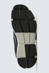 Zapatilla deportiva azul marino con detalles en gris oscuro y blanco. La parte superior está fabricada en combinación de piel con acabado serraje y tejido técnico transpirable. Cuenta con una suela ligera y voluminosa.