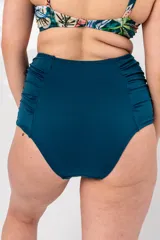 Bombacha de bikini tiro alto color azul petróleo, con laterales drapeados y refuerzo de faja en el interior delantero.