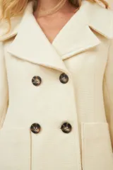 Chaquetón de lana con doble botonadura frontal, solapas anchas y bolsillos de parche delanteros. Presenta un diseño estructurado con forro interior al tono.