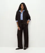Pantalón de corte recto y calce suelto, confeccionado en tejido de viscosa, poliéster y elastano. Presenta cintura elástica con cordón ajustable con punteras metálicas, recortes frontales y bolsillos traseros.