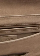 Bolso de hombro tipo baguette confeccionado en piel de serraje color tostado. Presenta un diseño rectangular con solapa frontal decorada con un detalle metálico y pespuntes visibles. Incluye un asa fija y forro interior.
