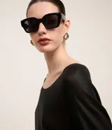 Blusa de punto color dorado, de acrílico y viscosa, con escote redondo, manga larga y sisa raglán. Tiene una malla con lámina metálica.