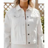 Campera de jean color negro con apliques de perlas en la parte superior frontal. Presenta cuello clásico, cierre frontal con botones metálicos y dos bolsillos en el pecho.
