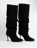 Botas de caña alta con diseño slouchy, confeccionadas en gamuza negra, con punta fina y taco aguja.