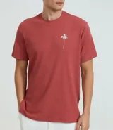 Remera de hombre color terracota, corte regular, cuello redondo y manga corta. Presenta un pequeño bordado de una palmera en el lado izquierdo del pecho.