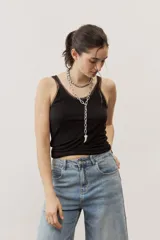 Musculosa negra de tirantes finos con detalles translúcidos en los bordes y diseño ajustado al cuerpo.