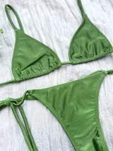 Conjunto de bikini verde con corpiño triangular y bombacha colaless con tiras para atar en los costados.