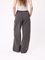 Pantalon de gabardina de corte recto y pata ancha, con cintura elástica y etiqueta decorativa en el frente.