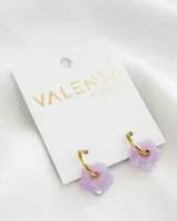 Aros colgantes con aro dorado y dije de flor lila de acrílico. El aro es de acero y la flor de acrílico.