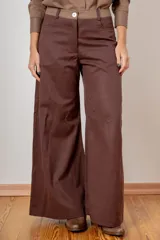 Pantalon de corte wide leg color marrón, con cintura alta, cierre frontal con botón y bolsillos laterales.