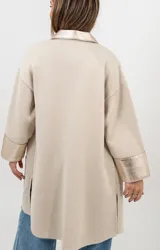 Camisa tipo sobrecamisa de lana en color beige, con detalles en cuero metalizado dorado en cuello, solapa frontal, puños y bolsillos. Presenta cierre frontal con botones a presión.