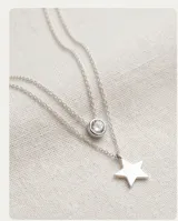 Collar doble de plata 925, compuesto por una cadena fina con un dije de circonia circular y otra cadena con un dije de estrella de plata.