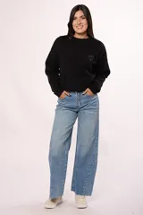 Pantalón de jean estilo wide leg con tiro alto, diseño de costuras diagonales en el frente y ruedo deshilachado.