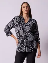Blusa negra con estampado floral blanco, cuello mao con escote en V y abertura frontal con botones. Manga 3/4 con terminación fruncida.