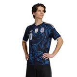 Camiseta de fútbol Adidas de la Selección Argentina, edición especial con diseño gráfico de hojas en tonos azules sobre fondo negro. Presenta el número 10 en el frente, el logo de Adidas, el parche de campeón del mundo FIFA 2022 y el escudo de la AFA.
