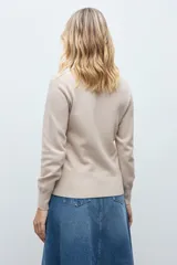 Sweater de punto color verde inglés, con cuello redondo y diseño de textura geométrica en relieve en la parte frontal.