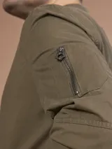 Campera bomber gris claro con cierre frontal y bolsillos laterales.