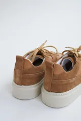 Zapatillas de gamuza verde oliva con cordones marrones y suela de goma color crema.