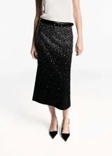 Falda midi de corte recto en color negro, confeccionada con detalle de strass brillante distribuido por toda la prenda. Presenta tiro medio y cintura con elástico para mayor comodidad.
