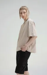 Remera de manga corta y cuello redondo, color beige claro, con calce boxy fit, caracterizado por ser ligeramente más corta y tener mangas amplias.