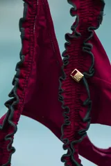 Bombacha de bikini tipo colaless con cintura ancha confeccionada en punto smock. Presenta un diseño en color marrón con bordes amarillos fruncidos.