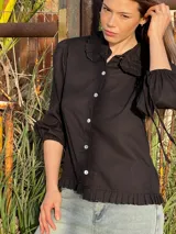 Blusa negra con cuello bebé con volados, mangas 3/4 abullonadas con lazo y botones blancos.