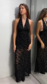 Vestido largo negro de cuello halter con escote en V pronunciado, confeccionado en tejido translúcido con diseño flocado de terciopelo con motivo floral.