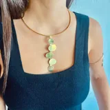 Gargantilla dorada rígida con dije colgante de cinco círculos de bronce.